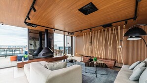 A modern living room with a sofa, coffee table, and a fireplace. - Movinn Nine - Jardim Paulista (São Paulo)