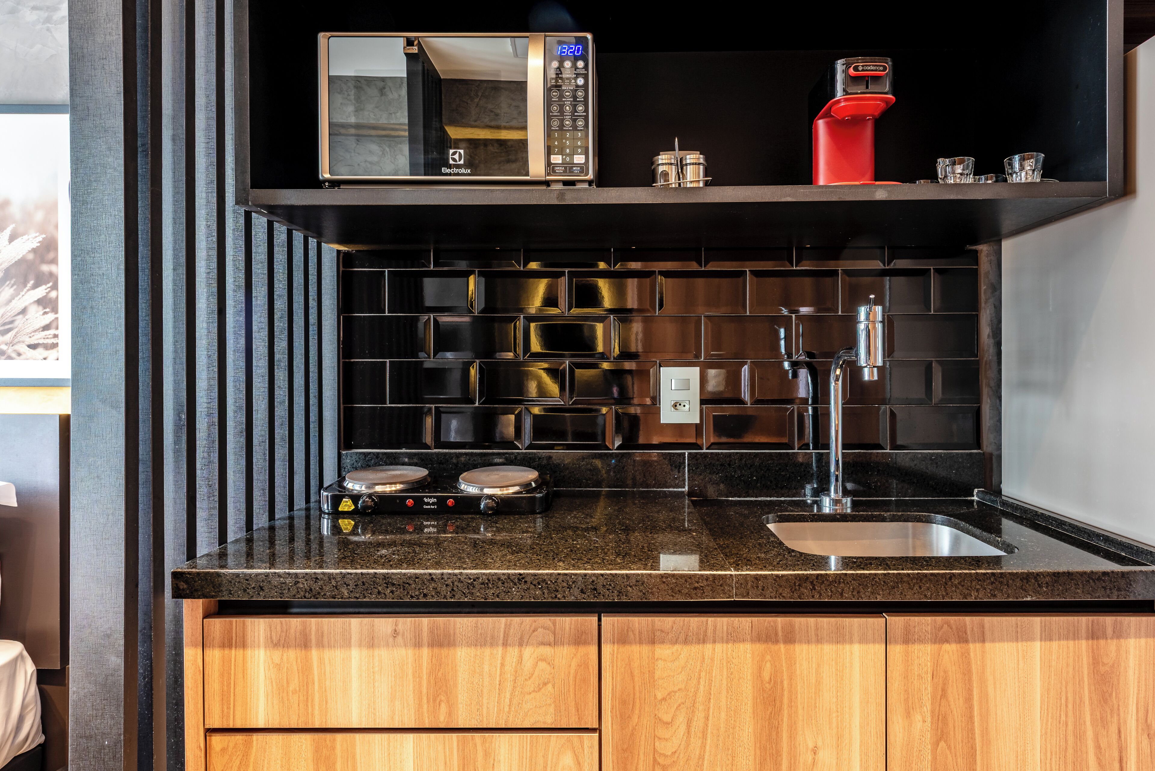 Une cuisine moderne équipée d’un four à micro-ondes, d’une machine à café et d’un évier.