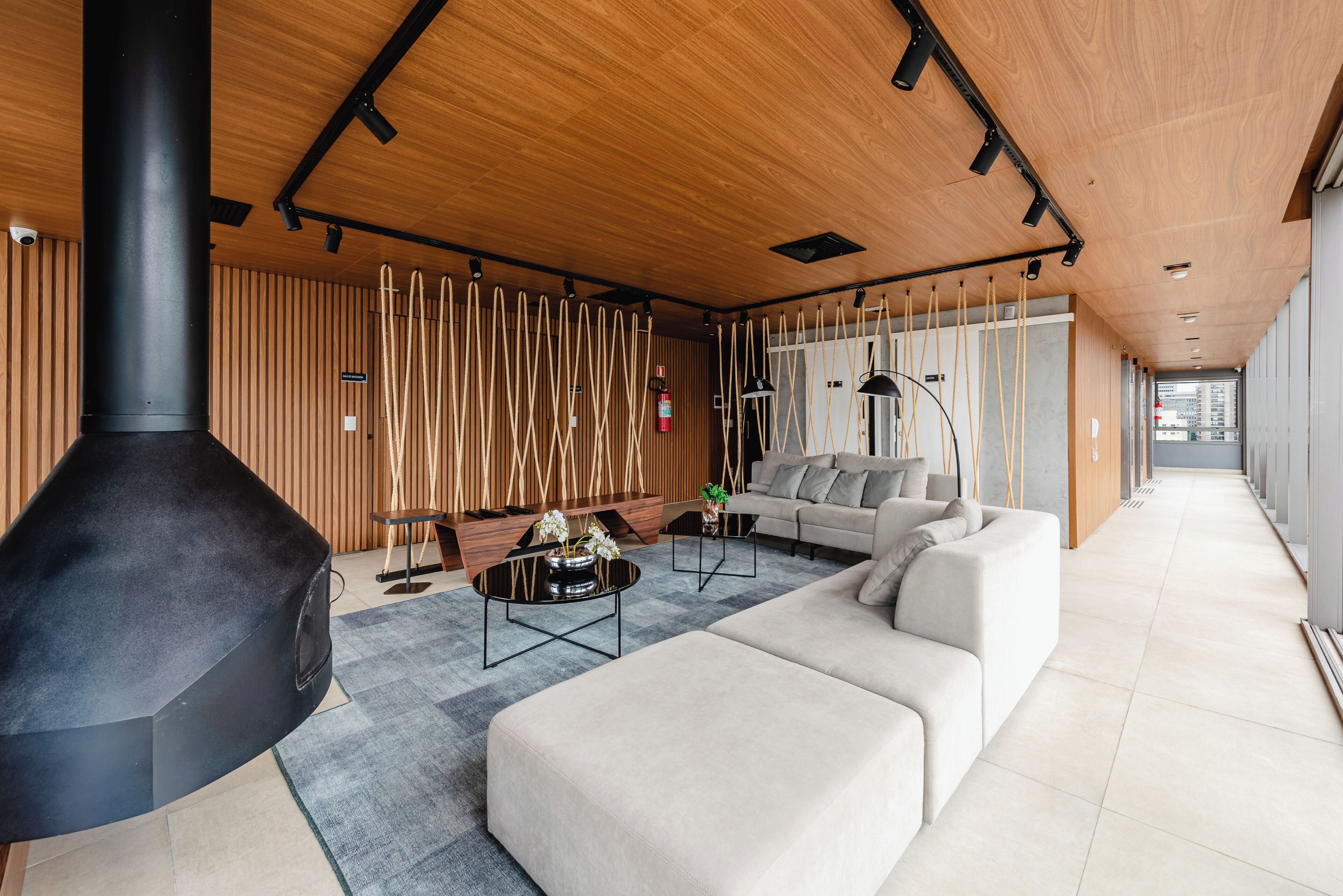 A modern living room with a fireplace, a sofa, a coffee table, and a wooden wall.