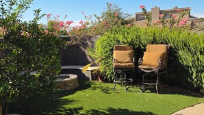 A garden area with a lawn, two chairs, and a stone bench. - Cozy Guest Suite with Private Backyard (Mesa)