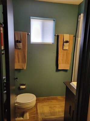A bathroom with a toilet, a window, and towels hanging on a rack. - Cozy Guest Suite with Private Backyard (Mesa)