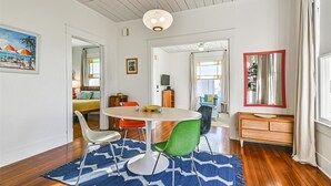 A dining area with a round table, chairs, and a blue patterned rug.