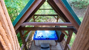 A hot tub on a wooden deck with a view of the forest. - Mountain View Cabin with Hot Tub, Fire Pit & Deck (Sevierville)