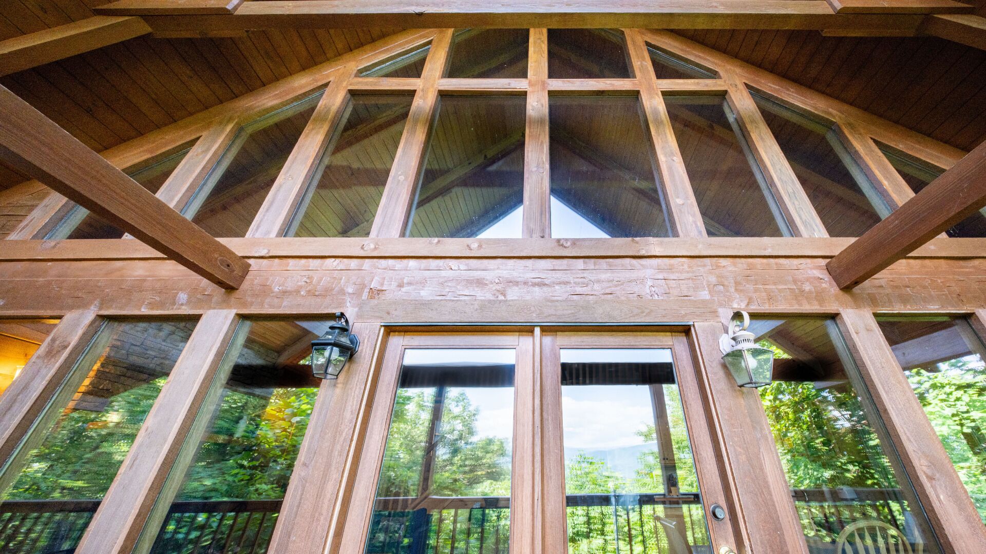 A wooden structure with large windows and a door, likely a part of a building's exterior.