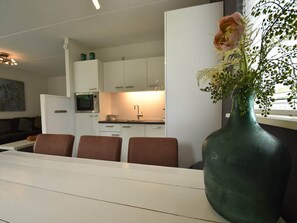 Cozy living space with a dining area, kitchenette, and large window.