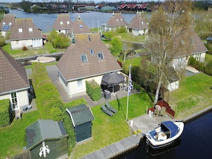 Stunning riverside homes with gardens and outdoor seating areas, offering a peaceful community atmosphere.