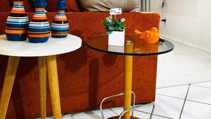 Una sala de estar moderna con un sofá, una mesita de centro de vidrio y jarrones decorativos.