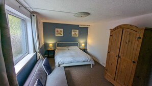 A bedroom with a bed, bedside lamps, a wardrobe, and a window with curtains. - Spacious Apartment with Private Terrace (Newtownards)