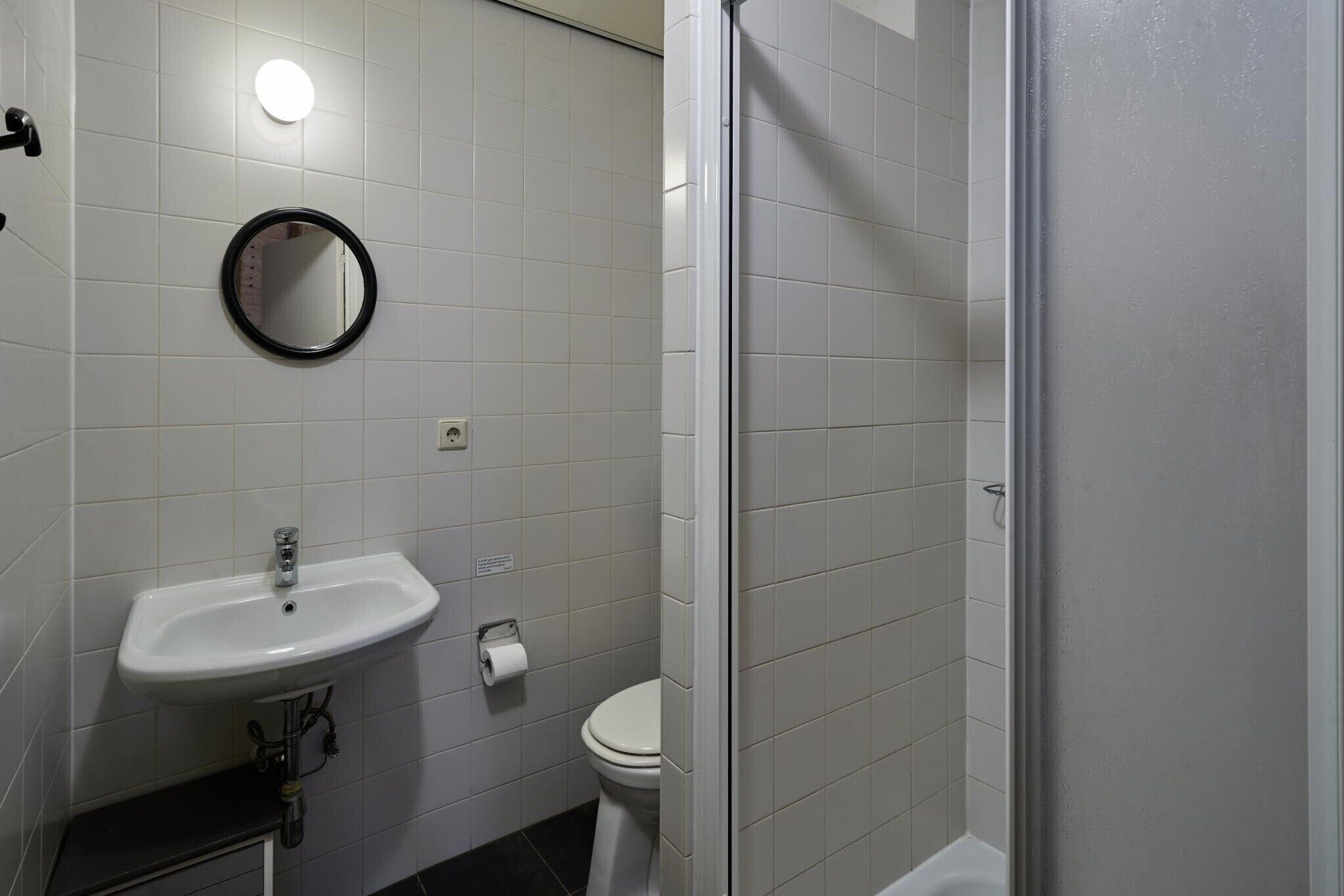 Ein Badezimmer mit Waschbecken, Toilette und Duschbereich.