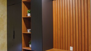 Una habitación compacta con escritorio, silla, armario y estanterías empotradas.