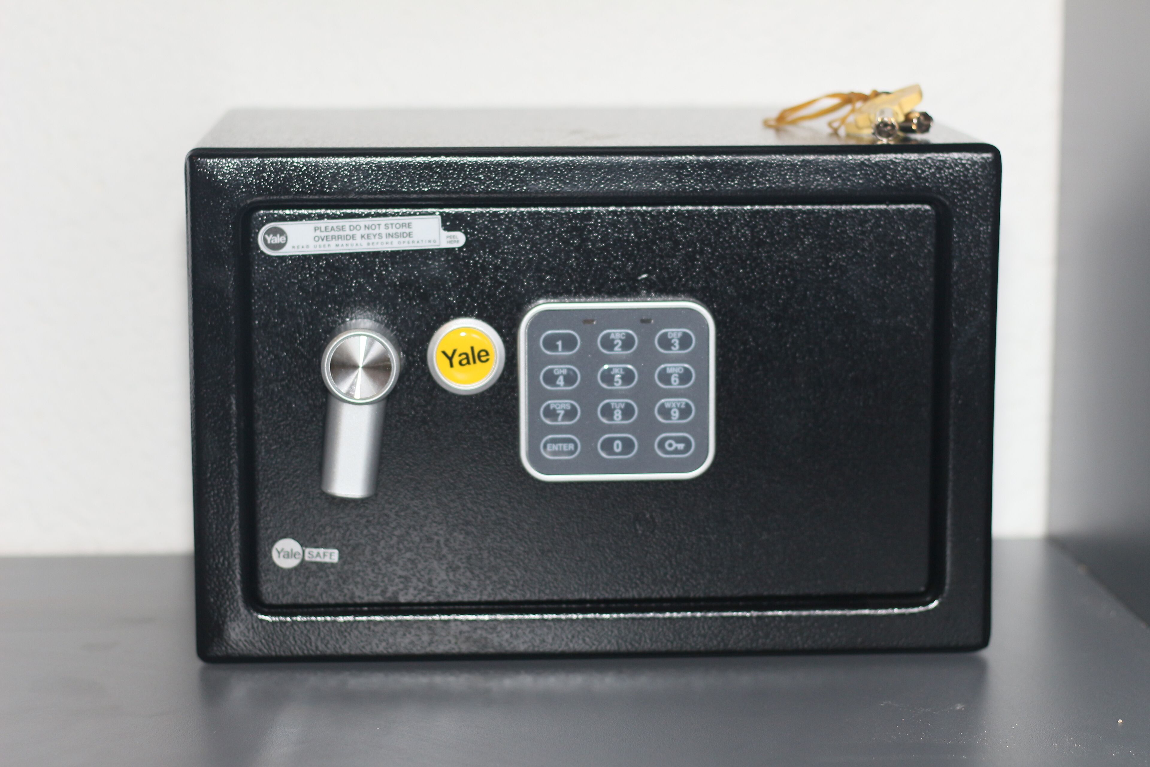 Una caja fuerte Yale negra con un dial de combinación y teclado.