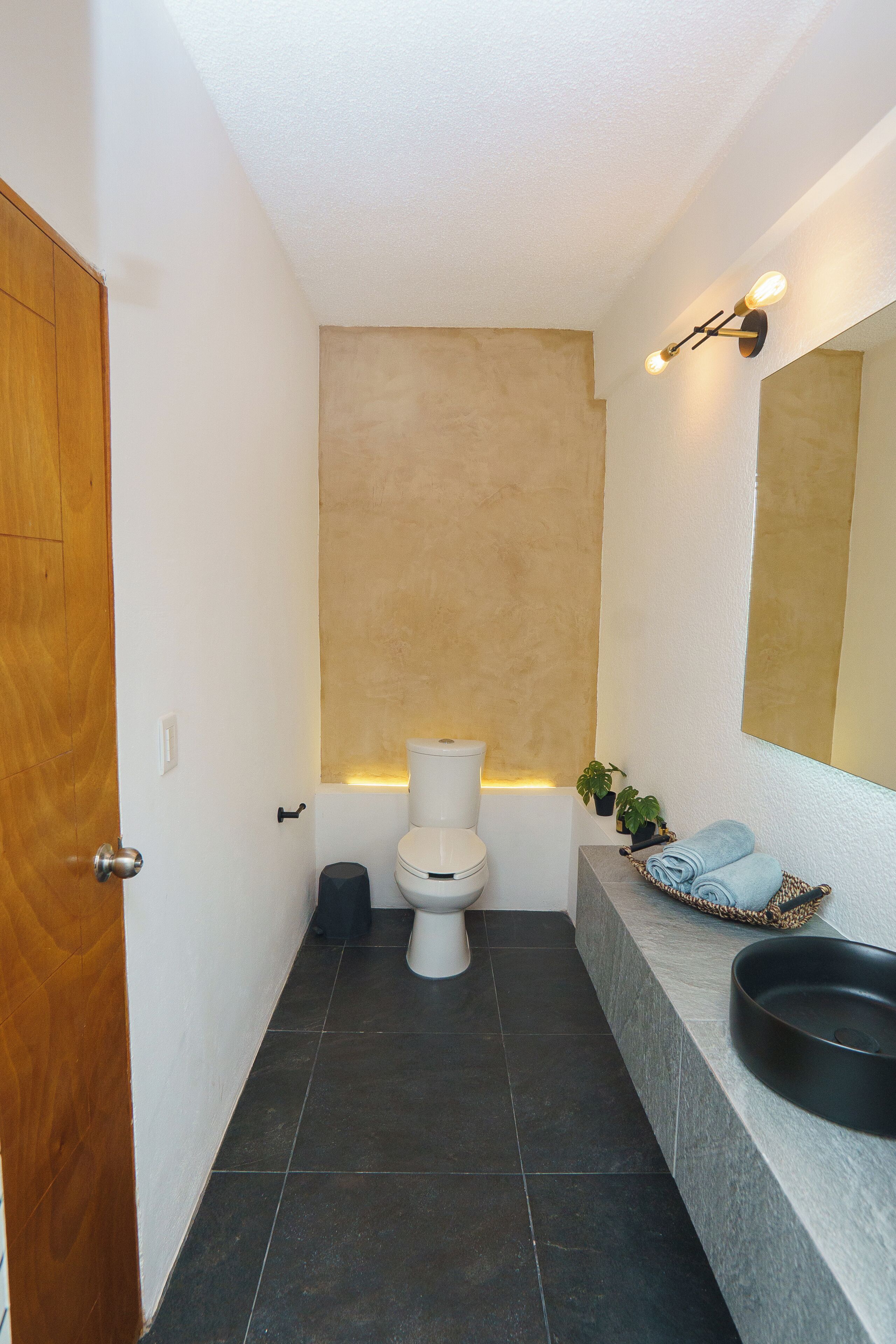 Une salle de bain moderne avec des toilettes, un lavabo et un miroir.