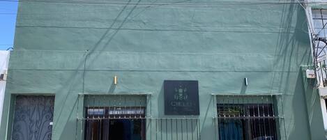 A building with a green facade, a metal gate, and a sign that reads "Cielo Carretera."