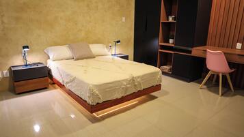A bedroom with a bed, bedside tables, a desk, and a chair.