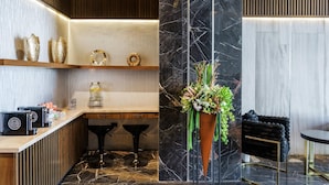 A modern kitchen with marble countertops, wooden cabinets, and a central island. - Radisson Puebla Angelopolis (Puebla)