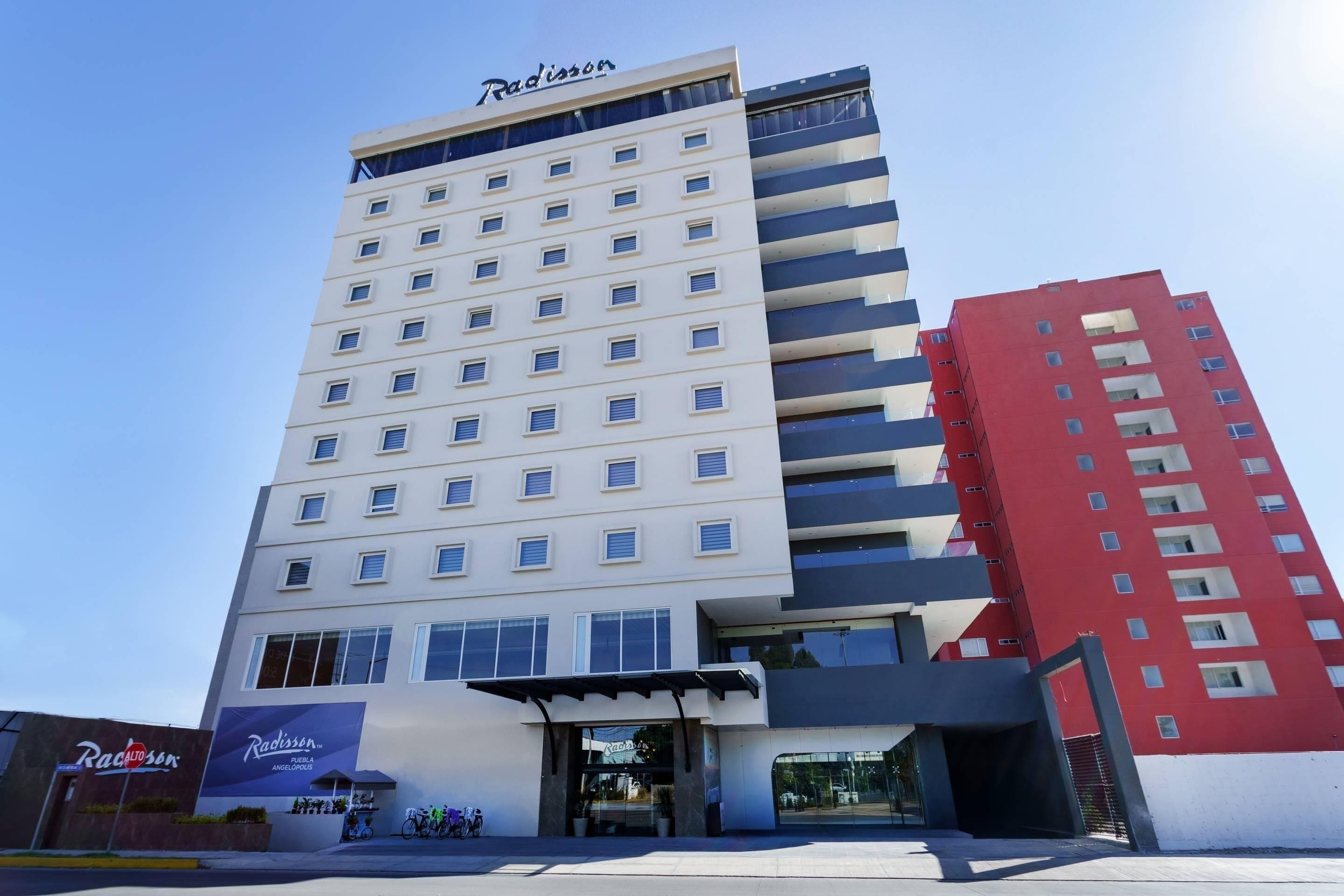 Un hotel Radisson con fachada moderna, varios pisos y una entrada destacada.