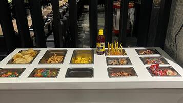 Een buffet in restaurant Carmina met diverse snacks en sauzen.