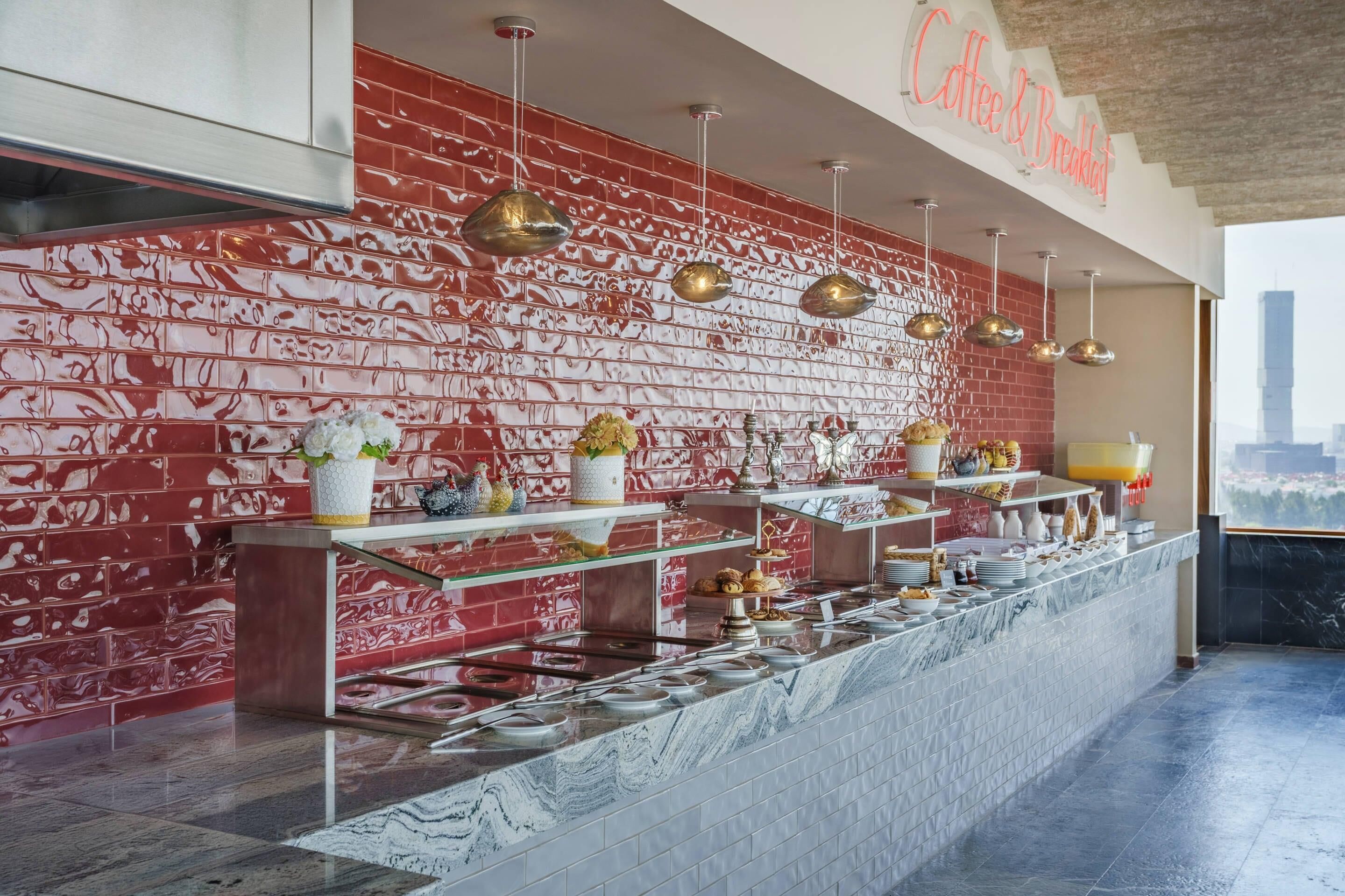 A breakfast bar with a red brick wall, hanging pendant lights, and a city view.