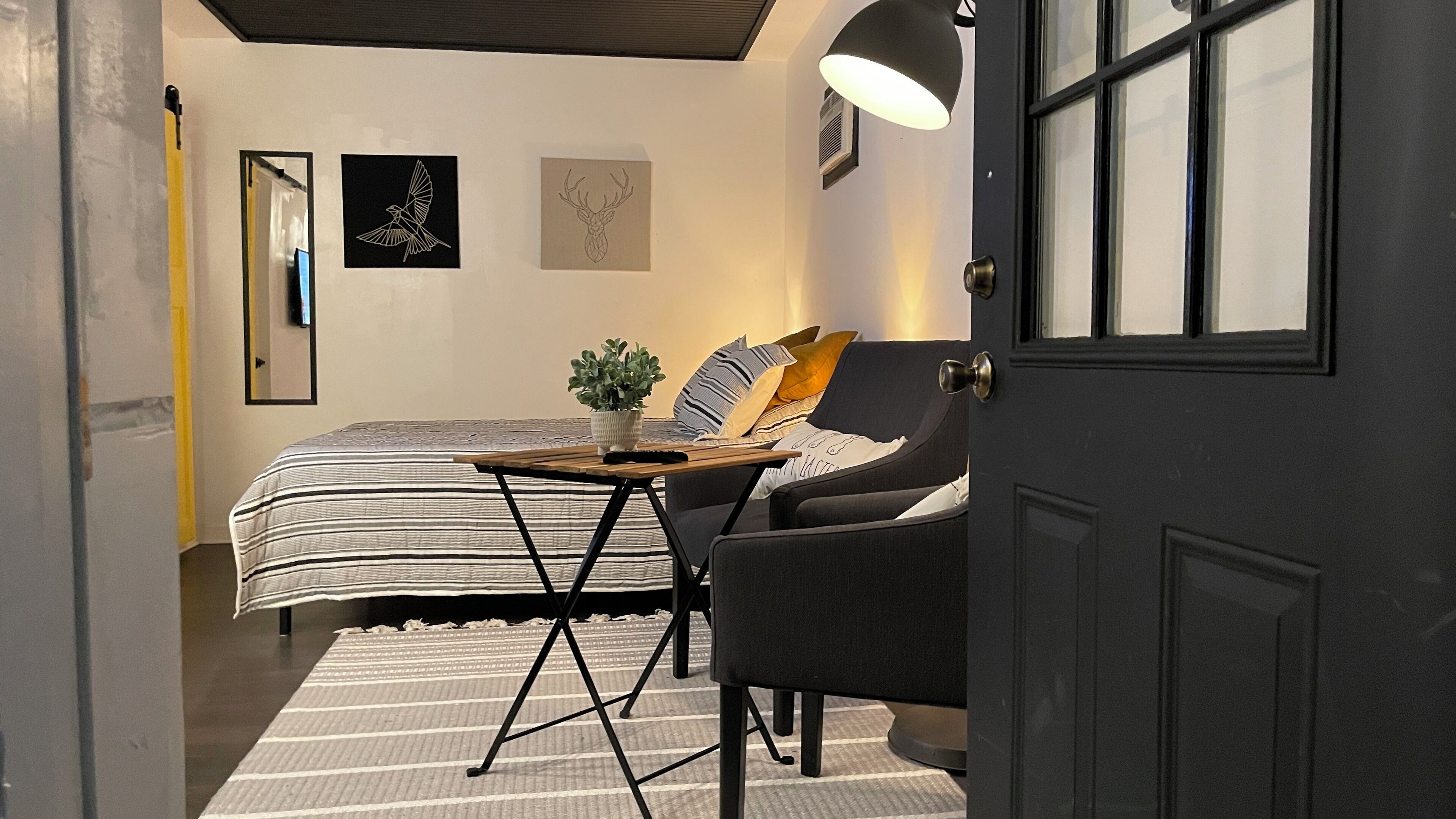 Ein Schlafzimmer mit Bett, Nachttisch, Lampe und Stuhl.