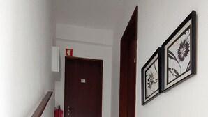 Una escalera con escalones de mármol, barandilla de madera y una puerta al final.