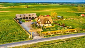 A rural property with a large house, a barn, and expansive green fields.