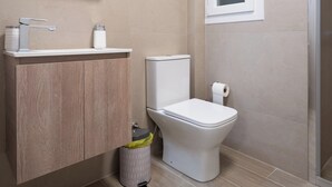 A modern bathroom with a toilet, sink, and mirror. - Ilisia 2 person apartment by MPS (Athina)