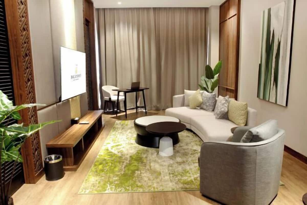 Un salon moderne avec un canapé, une table basse, un téléviseur et une plante.
