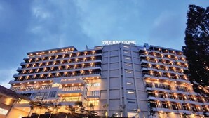 A multi-story hotel with balconies and a sign reading "THE BAY CONE". - The Balcone Suites & Resort (Gadut)