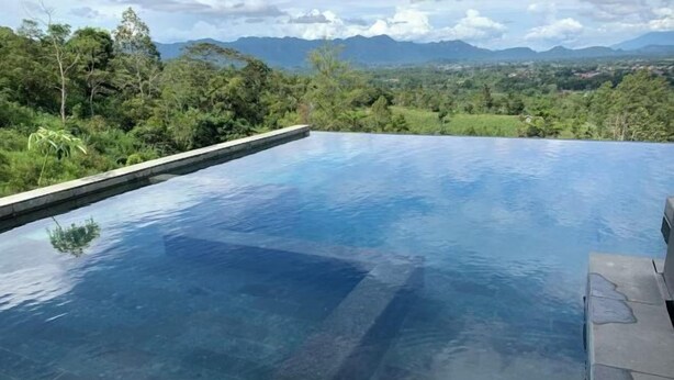 A clear view of an infinity pool with a mountain backdrop. - The Balcone Suites & Resort (Gadut)