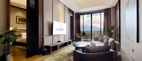 Una camera d'albergo moderna con un letto grande, una TV, un divano e un balcone con vista.