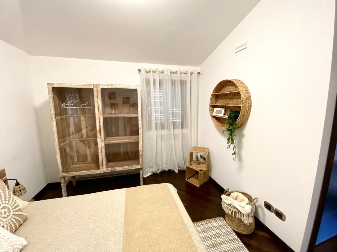 Une chambre à coucher avec un lit, une armoire, une étagère ronde et une petite table.