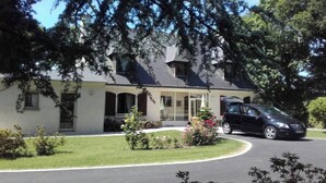 Une maison à deux étages avec une allée et une voiture garée.