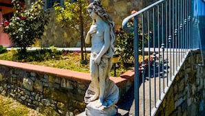 Un bâtiment en pierre surmonté d’une statue de femme posée sur un piédestal.