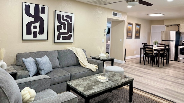 A modern living room with a gray sofa, a coffee table, and abstract art on the wall.