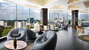 A modern, spacious lounge with high ceilings, large windows, and a panoramic city view. - Novotel Nairobi Westlands (Nairobi)