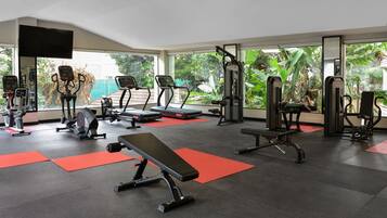 A gym with treadmills, weight machines, and a bench.