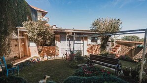Patio trasero residencial con una bicicleta, un banco y una escalera que sube a un segundo piso.
