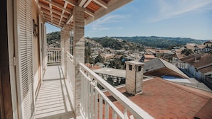 Un balcón con vistas a un pueblo y colinas.