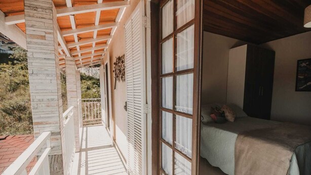 Un dormitorio con cama, ventana y balcón.