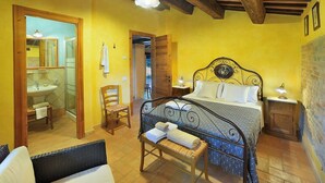 Ein Schlafzimmer mit einem Bett, einem Sessel, einem Nachttisch und einem Beistelltisch.