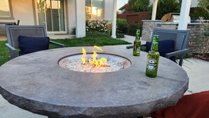 Una mesa de piedra con un hogar y una botella de cerveza Heineken, junto con otras dos botellas de cerveza.