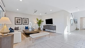A modern living room with a sofa, coffee table, and TV. - Blue Heaven (Roseville)