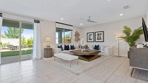 Una sala de estar moderna con un sofá blanco, una mesa de centro y un ventanal grande.