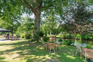 Un espace extérieur paisible, aménagé avec une table et des chaises, un barbecue et un bassin.