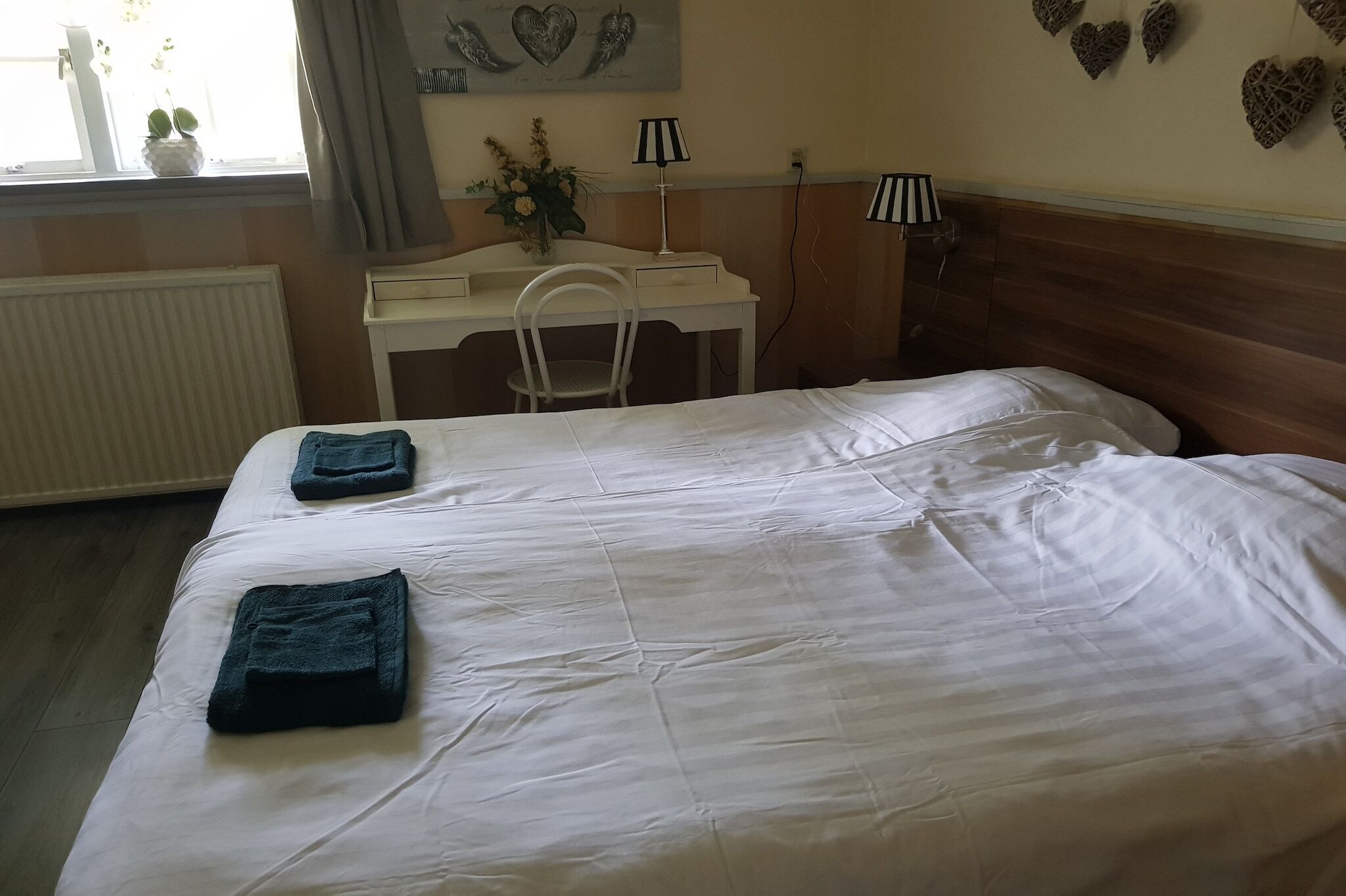A bedroom with a bed, a desk, and a chair.
