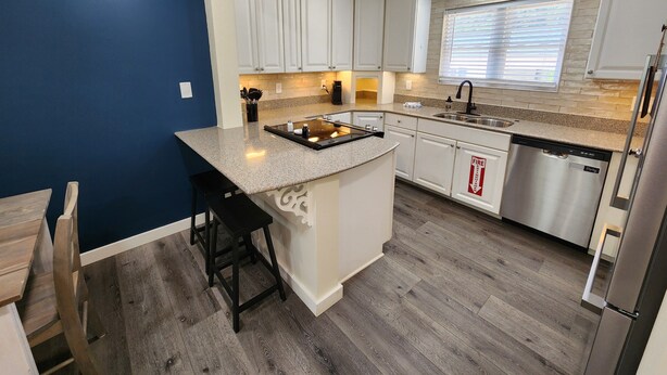 A modern kitchen with white cabinets, a granite countertop, and a stainless steel dishwasher. - Family-friendly, playroom w/ air hockey & arcade games, hot tub, mountain views! (Seymour)
