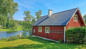 A red wooden house with a sloped roof, a chimney, and two windows. - 3 bedroom cozy home in Mellerud (Mellerud)