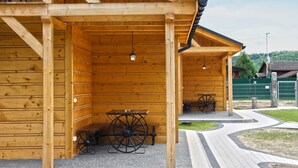 Un edificio in legno con un portico coperto, panchine e un filatoio.