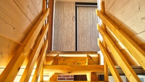 Una scala di legno conduce a una stanza con una grande finestra e una porta.