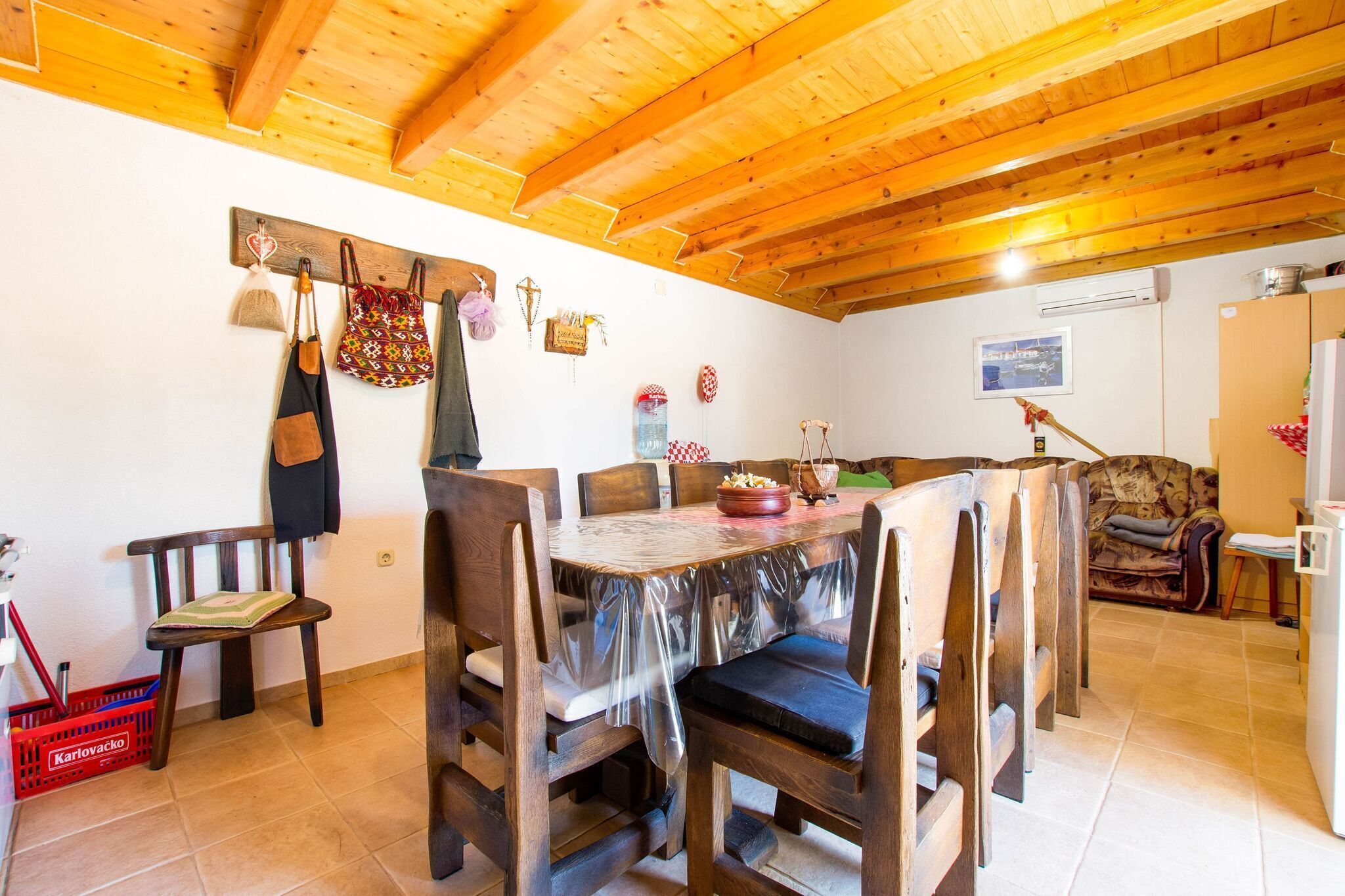 Un comedor de madera con una mesa y sillas, techo de madera y una cesta roja en el suelo.